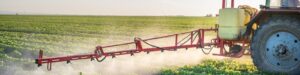 Obraz przedstawia lancę opryskiwacza rolniczego wykonującego oprysk pola